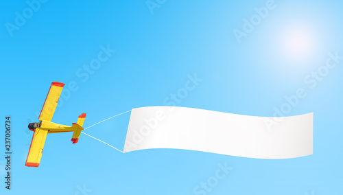 old vintage retro propeller engine airplane flying with white banner isolated on blue sunny sky air travel aviation tourism theme panorama copy space landscape background aerial view design wallpaper