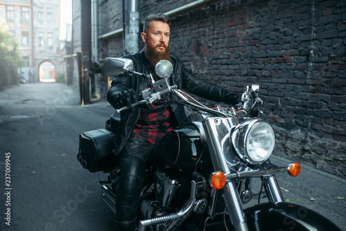 Motorcyclist in leather jacket poses on chopper © Nomad_Soul