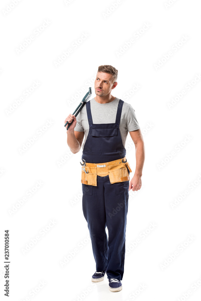 serious plumber in overalls holding pipe wrench isolated on white serious plumber in overalls holding pipe wrench isolated on white