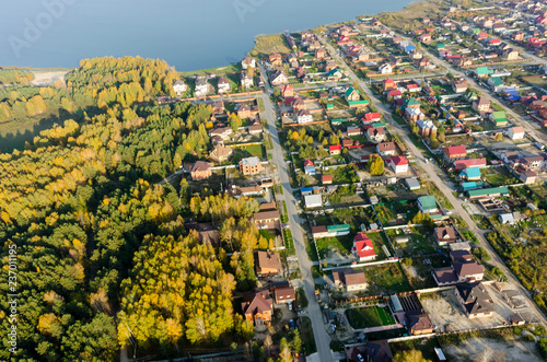 Borovskiy, Russia - September 26, 2016: Aerial view onto Novaya Ozernaya - New Lake street on border with autumn forest photo