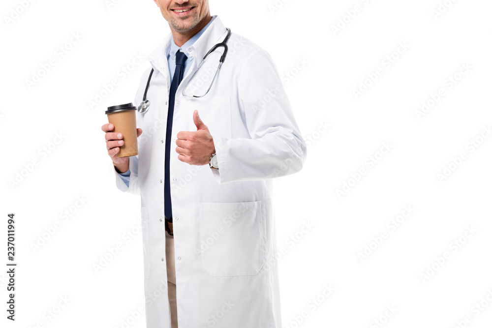 cropped view of smiling doctor holding coffee to go and doing thumb up sign isolated on white cropped view of smiling doctor holding coffee to go and doing thumb up sign isolated on white
