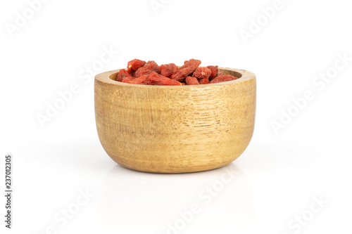 Lot of whole dried red goji berries with wooden bowl isolated on white background