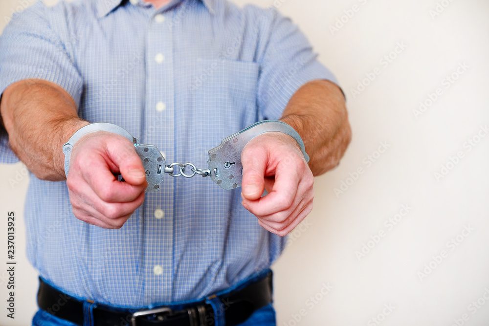 Fototapeta premium Handcuffs on the wrists of the detained man