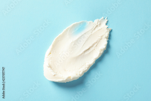 Smear of tasty cream cheese on color background, top view