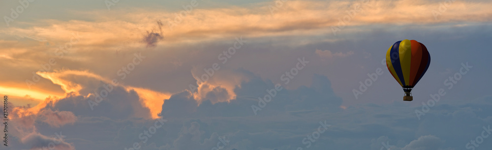An aerostatic balloon among the clouds at sunset