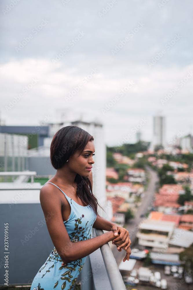 Fototapeta premium Pensive trendy woman on balcony above city