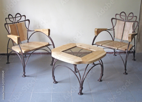 Two wooden chairs and a table with elements of forging. Home furniture made of wood. Interior design