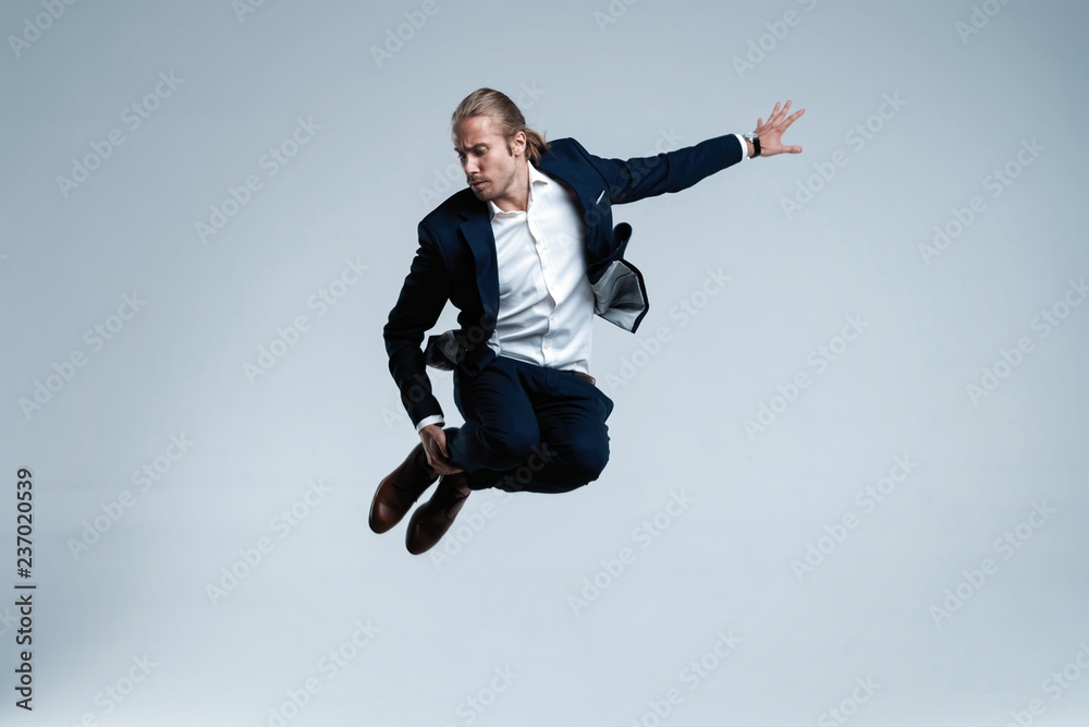 Young successful businessman in suit rejoicing, jumping over white background. Young successful businessman in suit rejoicing, jumping over white background.