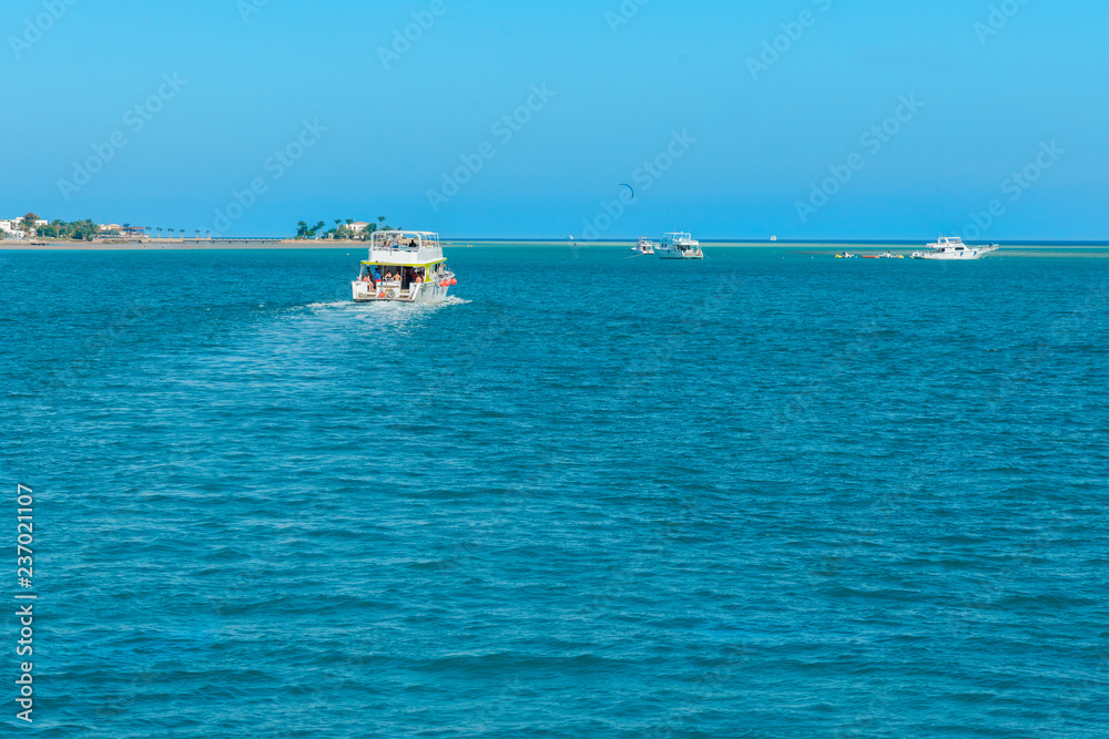 several pleasure boats in the sea near the islands. boats in beautiful turquoise ocean near an island.