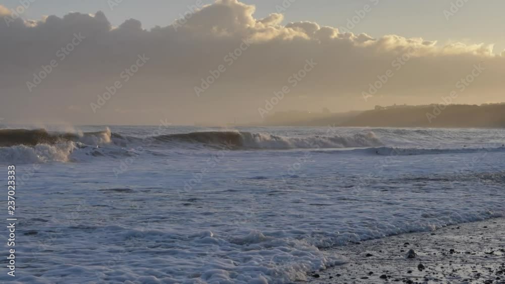 Waves and ocean spray crashing on the beach at sunrise. Waves and ocean spray crashing on the beach at sunrise.