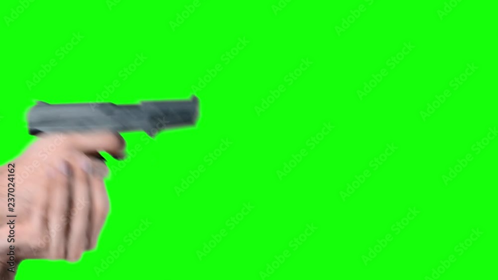 Man on green screen chroma key background shooting with a pistol