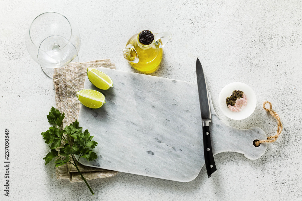 marble cutting board, spices, olive oil and cut lime on the table. copy space marble cutting board, spices, olive oil and cut lime on the table. copy space