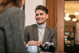 Smiling man talking with the woman in the cafe