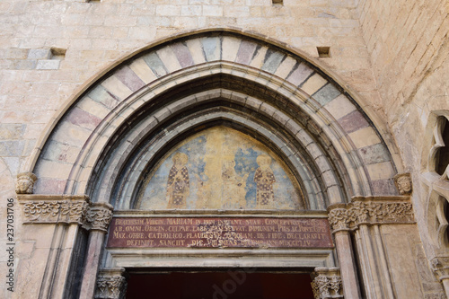 painting the tympanum of portico in the south facade of Basilica of Sant Feliu in Girona, Catalonia, Spain