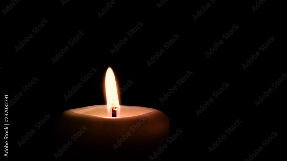 burning candle with flame sliding on black background burning candle with flame sliding on black background