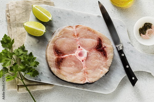 Foto raw swordfish steak on a marble cutting board with olive oil and spices