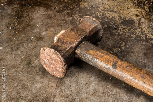 Old rusty hammer on old metal table background. Closeup view of vintage blacksmith hammer.