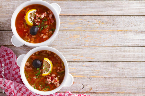 Traditional Russian dish solyanka - thick, spicy and sour saltwort soup. View from above, top studio shot, copy space