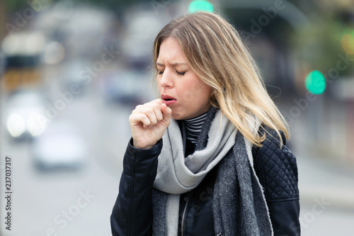 Obraz na plátně Shot of illness young woman coughing in the street.