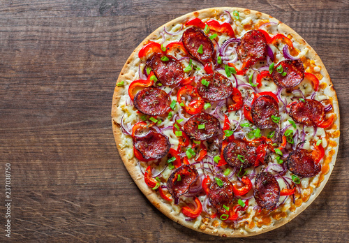 Pepperoni Pizza with Mozzarella cheese, salami, Tomato sauce, pepper, onion, Spices. Italian pizza on wooden table background