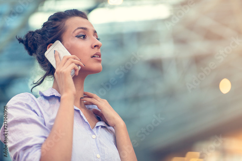 Young woman busy with calling, chatting on the cell phone side view portrait.