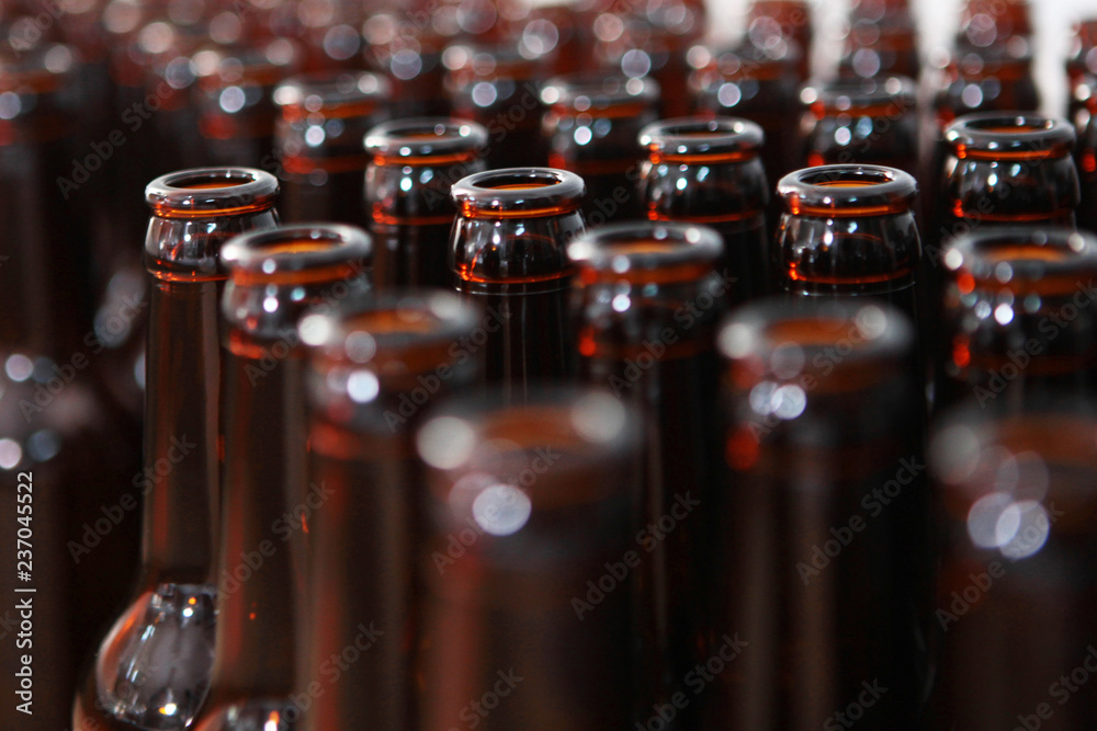 Empty beer bottles. One bottle in focus. All the other bottles are out of focus. Private beer factory. Beer from natural products.