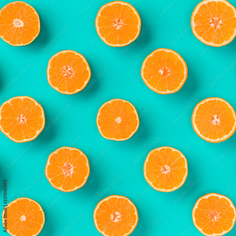 Fruit pattern of fresh mandarin slices on blue background. Flat lay, top view. Pop art design, creative summer concept. Half of citrus in minimal style. Tangerine. Fruit pattern of fresh mandarin slices on blue background. Flat lay, top view. Pop art design, creative summer concept. Half of citrus in minimal style. Tangerine.