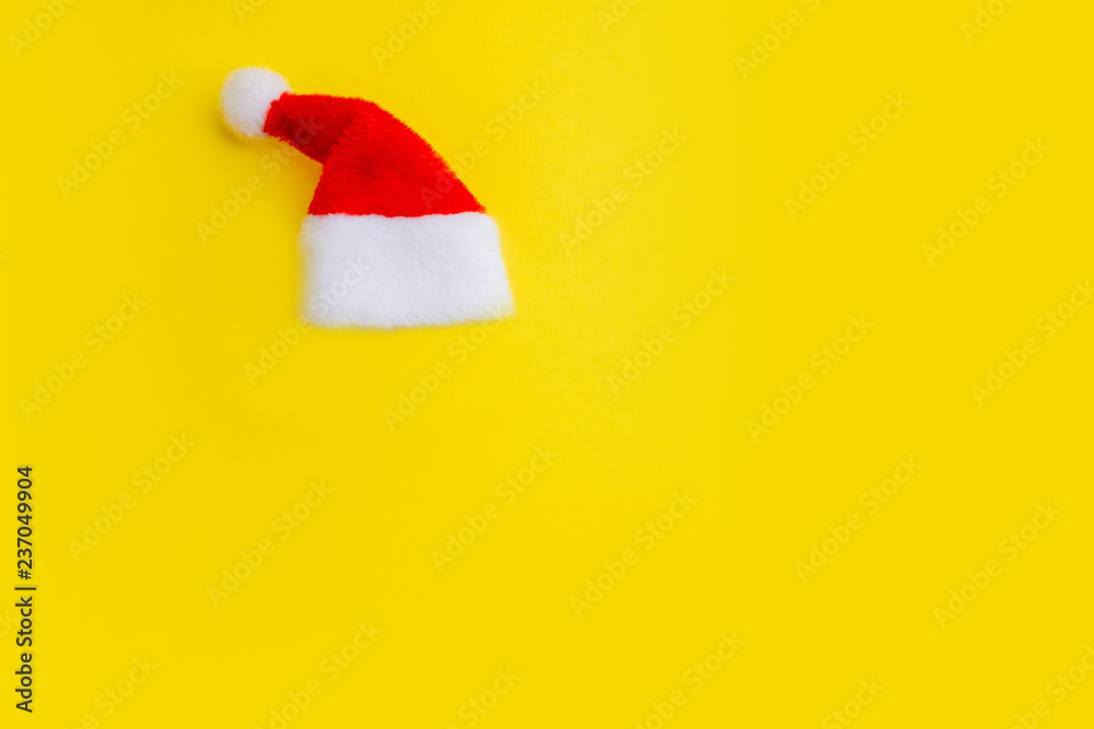 Red Santa Claus hat on a yellow background. Isolate The concept of the New Year and Christmas. Copy space.