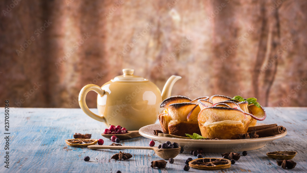 Fototapeta premium Crispy apple roses on color plate with several herbs and spices