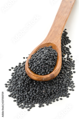 Heap of black organic beluga lentils in wooden spoon on white