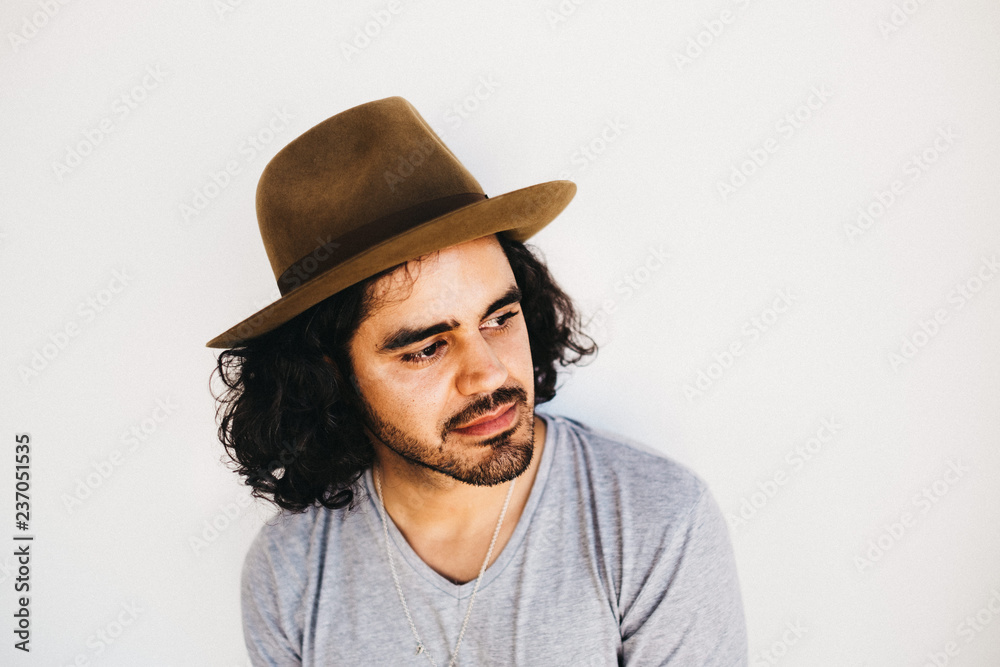Handsome ethnic man in hat holding camera Handsome ethnic man in hat holding camera