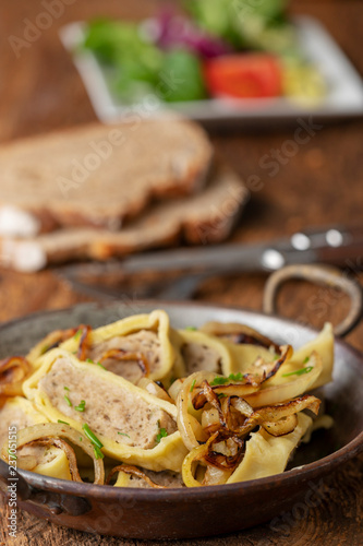 schwäbische Maultaschen mit Zwiebeln in einer Pfanne photo