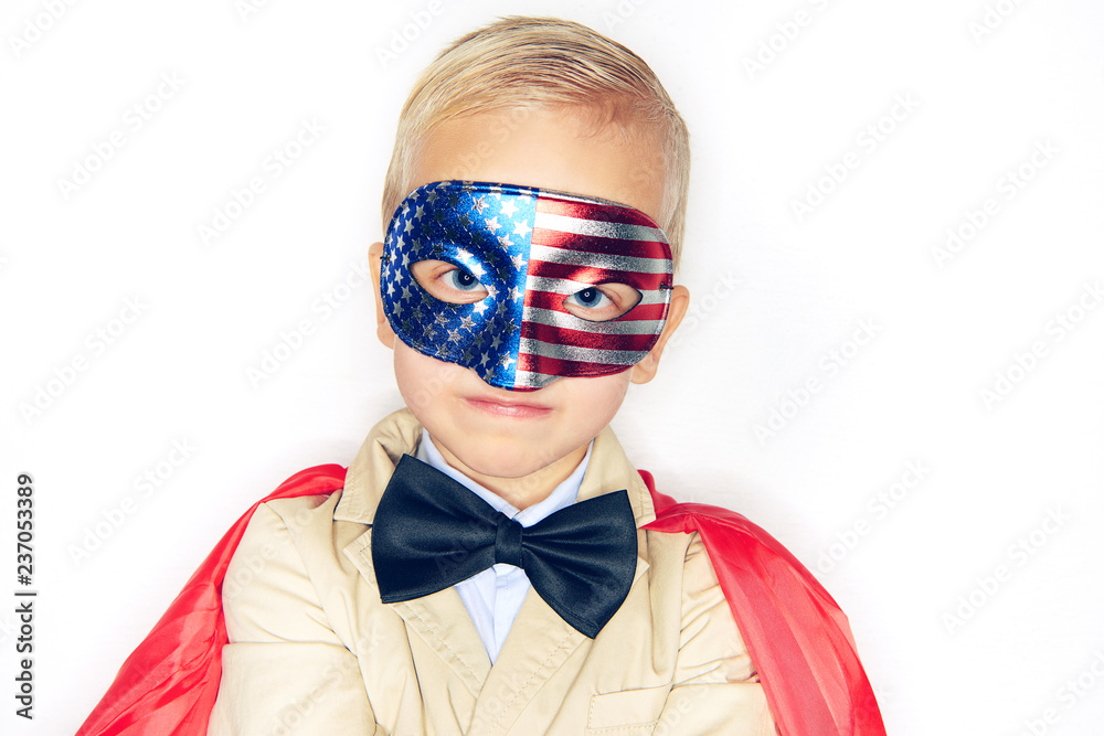 Cute little boy wearing a superhero cape and flag mask
