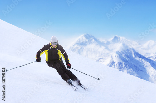 Alpine skier on piste running downhill