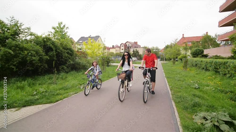 Parents With Their Kids Are Riding On Bikes. Happy Family Spending Time Together. Parents With Their Kids Are Riding On Bikes. Happy Family Spending Time Together.