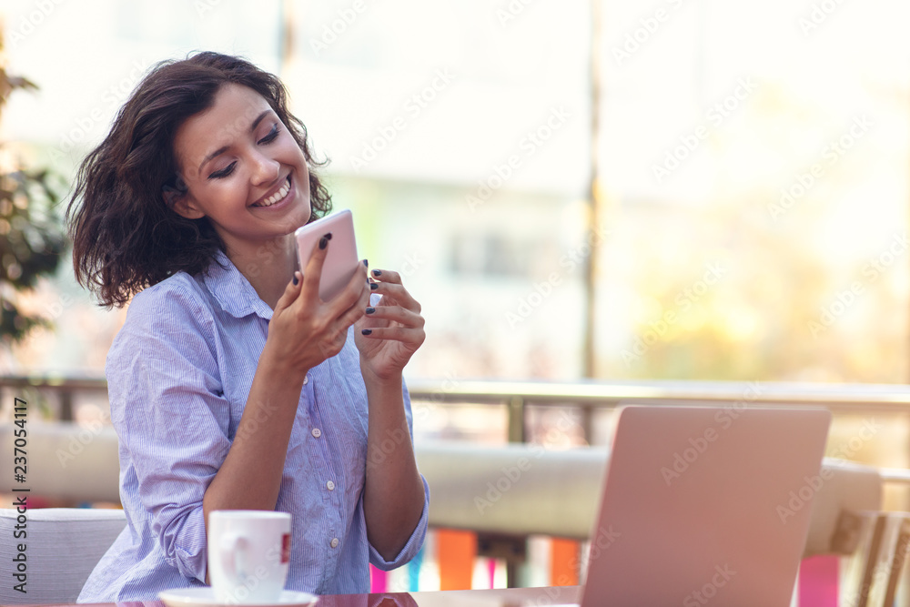 Businesswoman Using Phone While Working In Coffee Shop Businesswoman Using Phone While Working In Coffee Shop