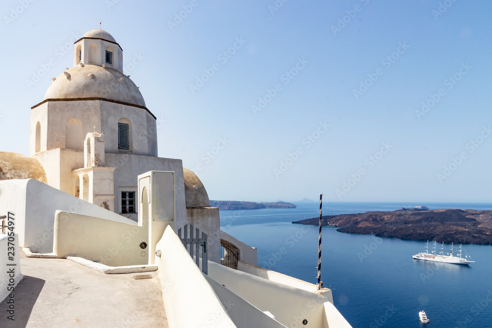 View of small chapel and cruise ship at santorini, greece