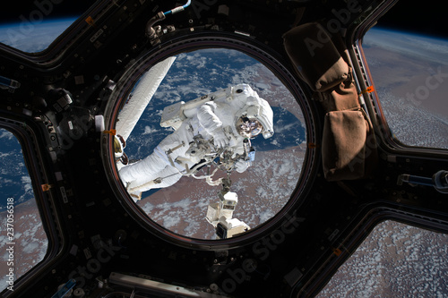 Fototapeta Naklejka Na Ścianę i Meble -  astronaut spacewalk near the earth. view from the space ship illuminator. Elements of this image furnished by NASA f
