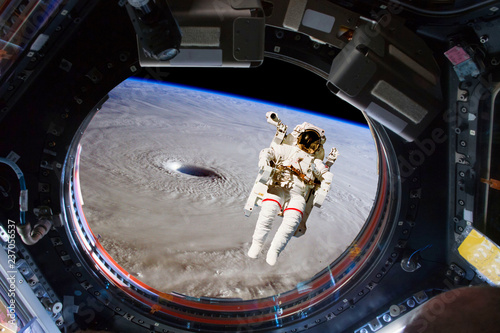 Fototapeta Naklejka Na Ścianę i Meble -  astronaut spacewalk near the earth. view from the space ship illuminator. Elements of this image furnished by NASA f