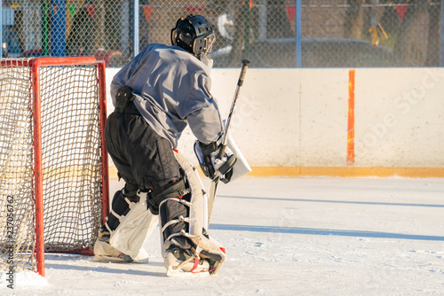 close up alone hockey goalkeeper protecting the gates during the match on the ice f photo