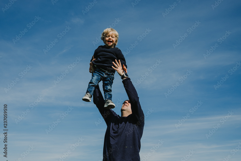 .Funny father playing with his son in the park on a sunny autumn day. Throwing him into the air, making him fly while the kid laughs. Lifestyle .Funny father playing with his son in the park on a sunny autumn day. Throwing him into the air, making him fly while the kid laughs. Lifestyle