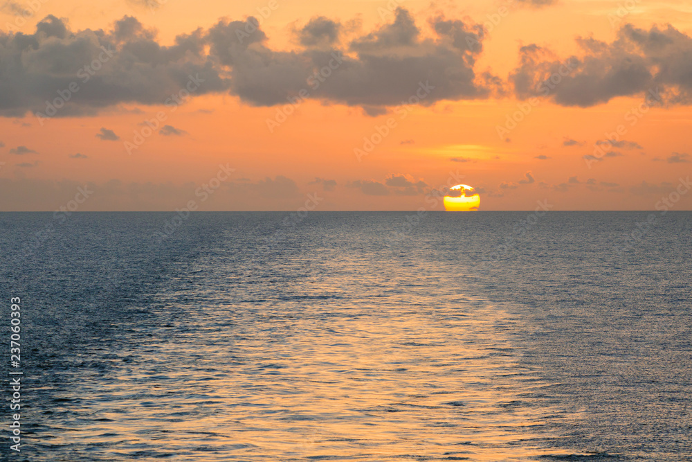 Wake on the blue sea water surface at sunset.