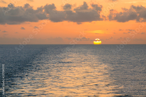 Wake on the blue sea water surface at sunset.