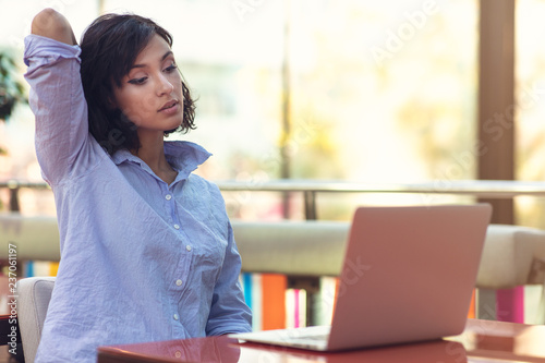 Image of happy woman using laptop while sitting at cafe.