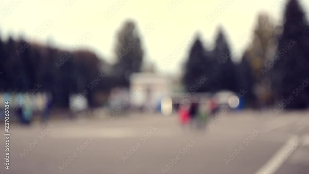 Many people walk by city square. People walking slowly relax on the town. Blurred Background of city or town. Beautiful abstract urban backdrop. Many people walk by city square. People walking slowly relax on the town. Blurred Background of city or town. Beautiful abstract urban backdrop.