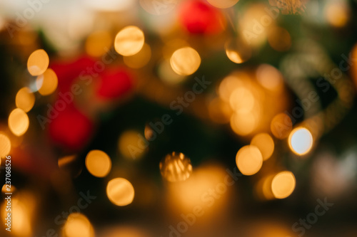 Bright abstract Christmas background with blurred lights and Christmas tree decoration.