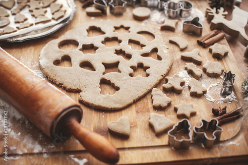 Quadro su tela Gingerbread dough with metal cutters for christmas cookies on rustic table with wooden rolling pin, cinnamon ,anise, cones, christmas decorations