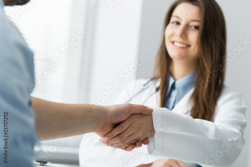 The doctor shakes hands with the patient