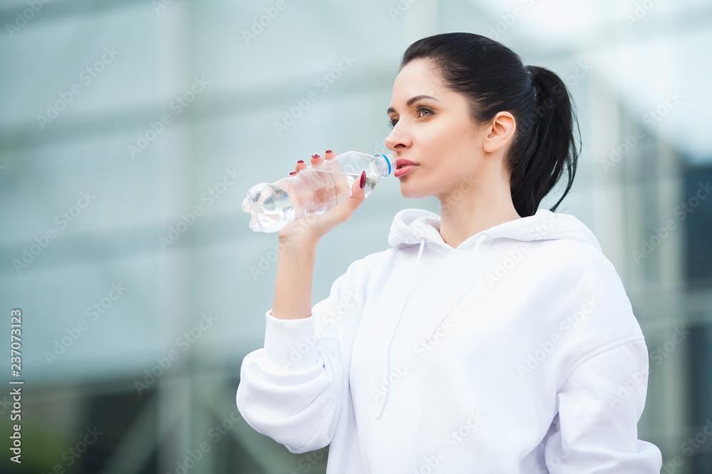 Fitness outdoor. Woman drinking bottle of water Fitness outdoor. Woman drinking bottle of water