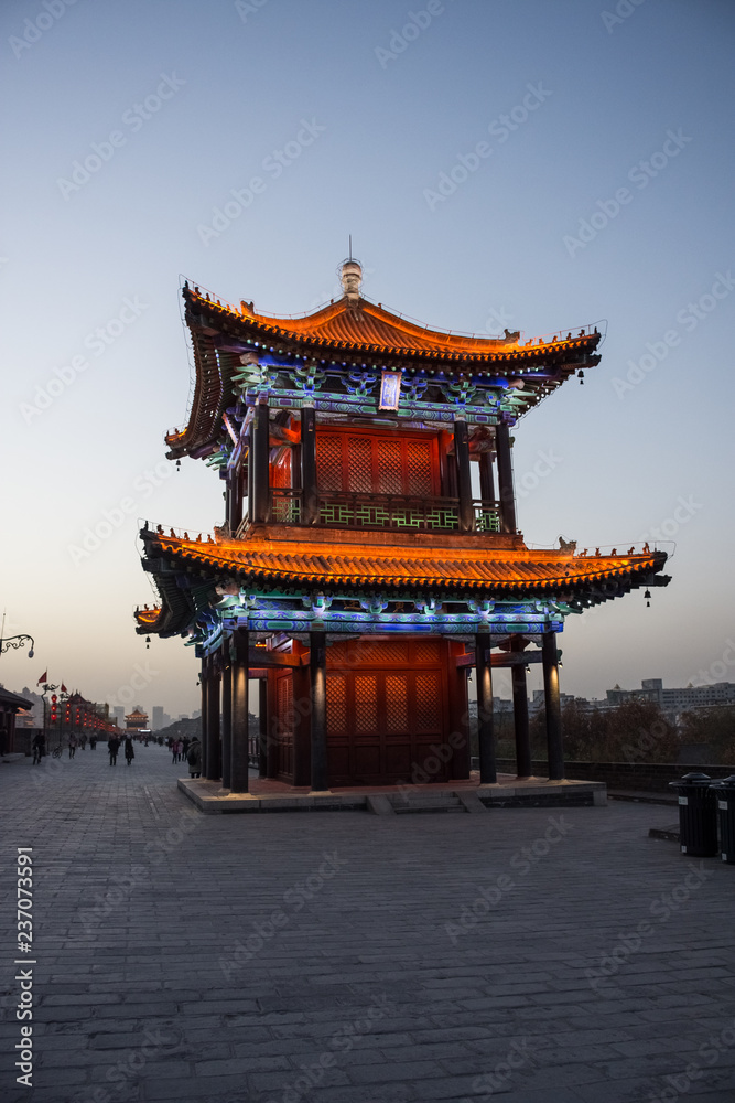 Fototapeta premium Beautiful illuminated traditional chinese temple on the Xi'An City Walls at evening, China
